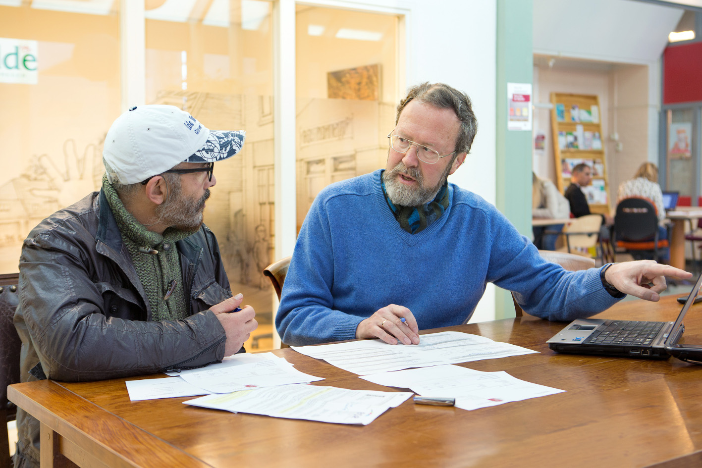 Foto: een medewerker van de Stip geeft uitleg aan een bezoeker van de Stip