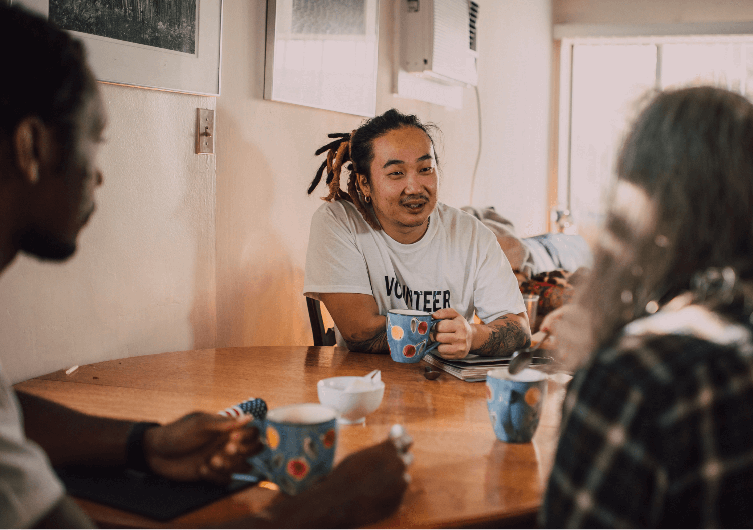 Vrijwilliger zit aan tafel met kop koffie