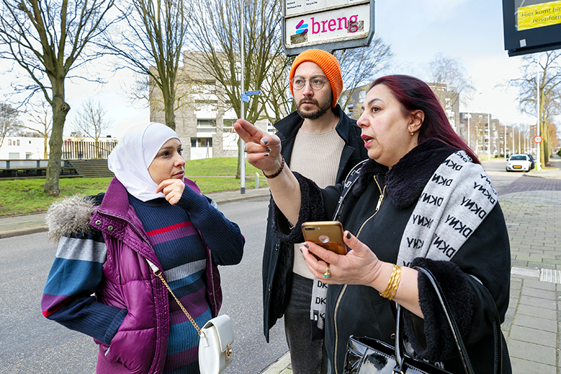 mensen die met elkaar praten bij de bushalte