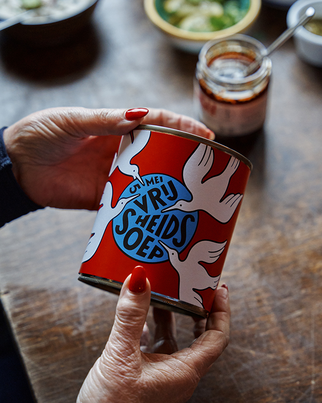 twee handen die een blik vrijheidssoep vasthouden